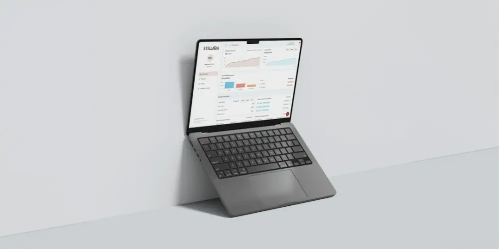 A grey laptop displaying a business dashboard against a plain light grey wall, illustrating enterprise software reviews